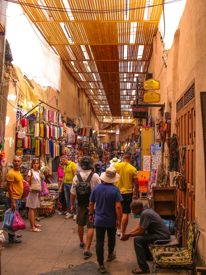 The Art of Drawing Readers In: Your attractive post title goes here Busy street scene in Marrakech medina featuring colorful shops and local visitors. Experience Moroccan culture.